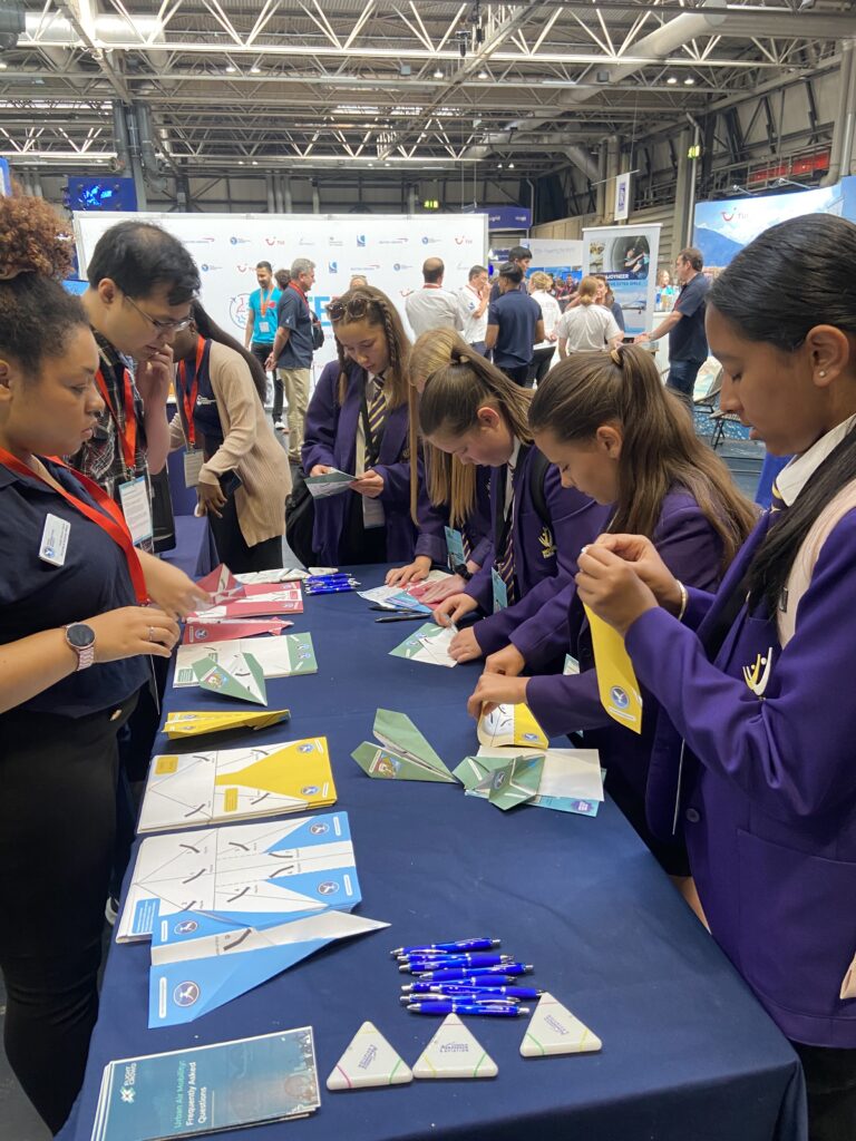A group of young women making paper planes